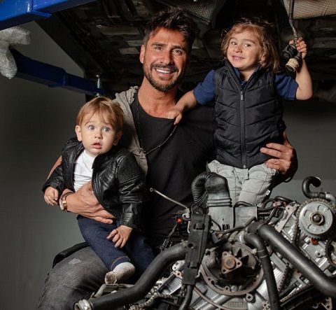 Julio Rocha posa com os filhos em oficina mecânica